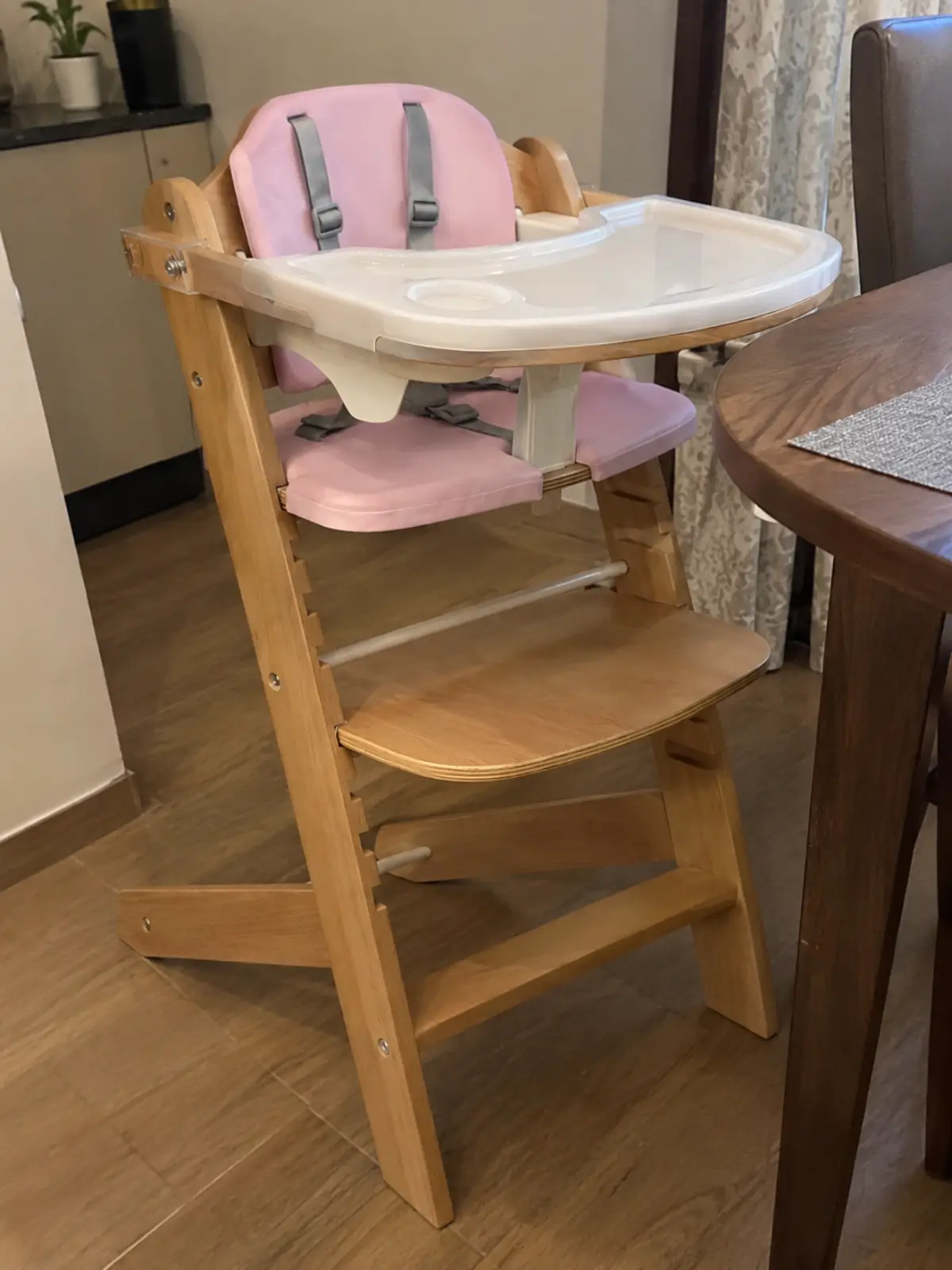 A Cowiewie 3-in-1 wooden high chair with pink cushions, harness and tray, owned by a parent we know
