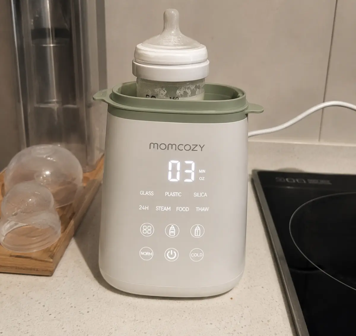 Our Momcozy bottle warmer in use on the counter, original photo