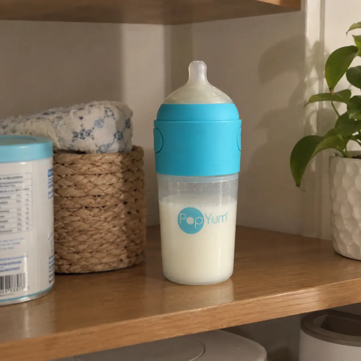 Our blue PopYum bottle with a made feed in it, on the nursery shelf, original photo